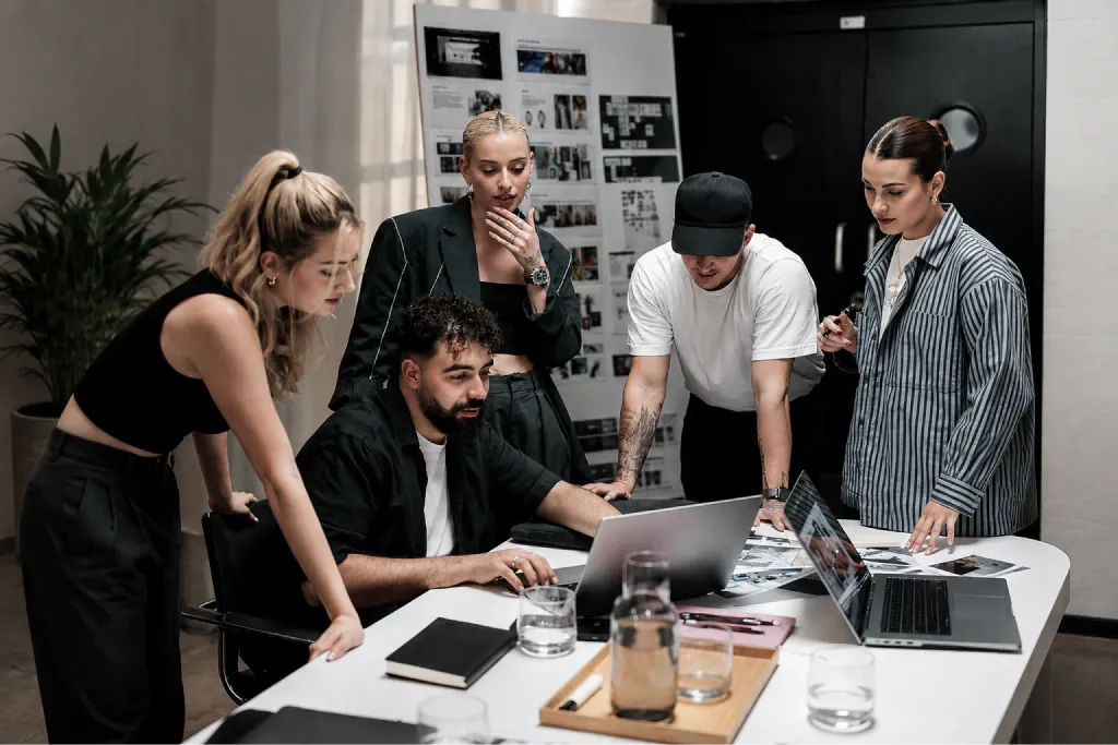 Avad Gate Marketing team reviewing campaign materials around a studio table