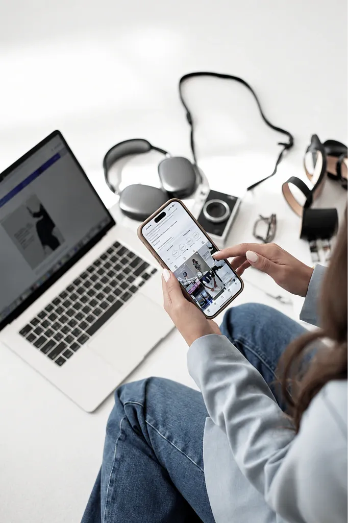 Team member reviewing a campaign on a phone next to a laptop